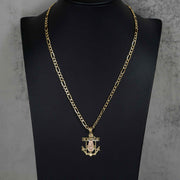 Close-up of the 14k gold two-tone anchor pendant worn on a Figaro chain.
