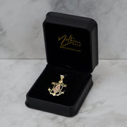 14k gold anchor pendant displayed neatly inside an open black velvet jewelry box.