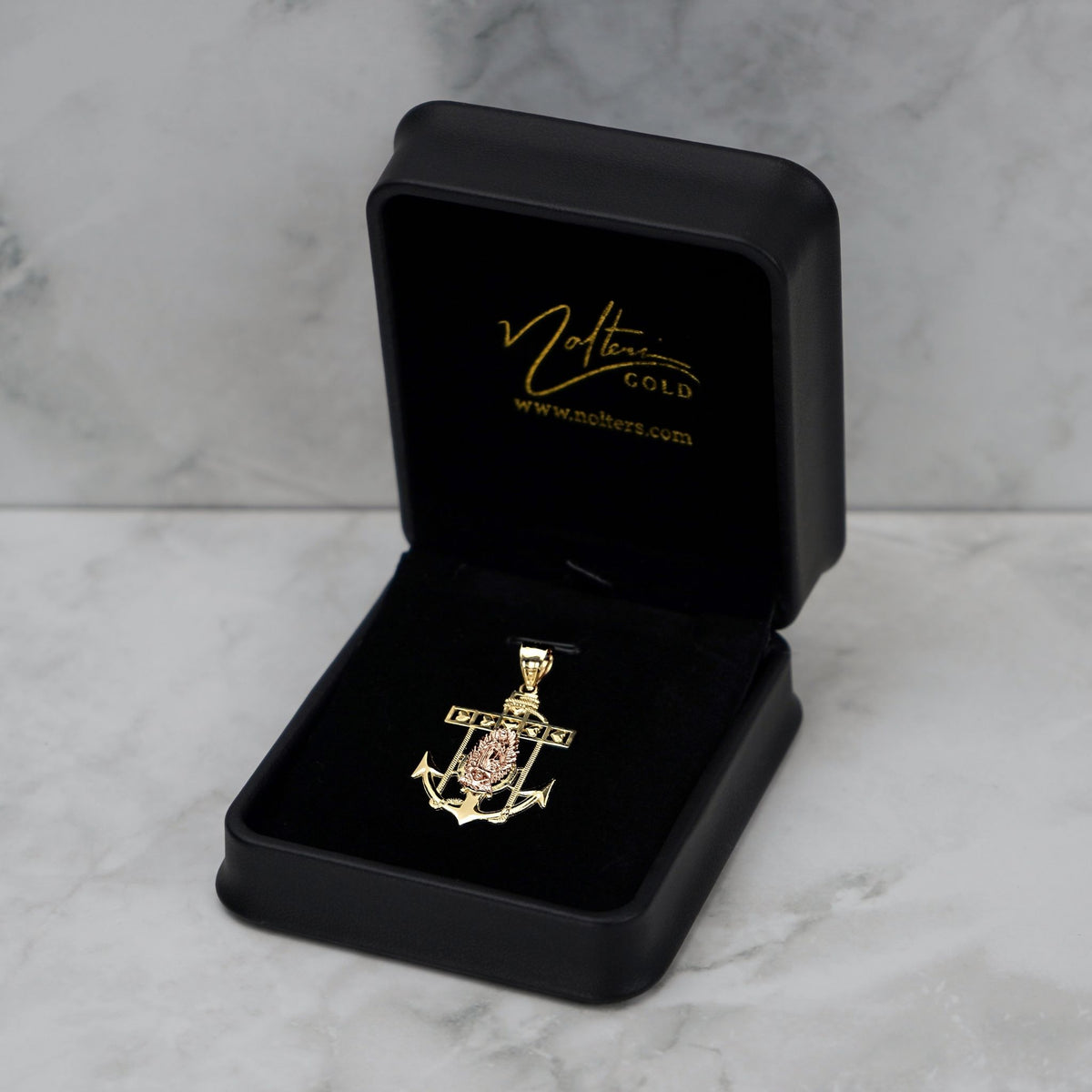 14k gold anchor pendant displayed neatly inside an open black velvet jewelry box.