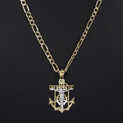 Front view of a 14k two-tone gold crucifix anchor pendant necklace on Figaro chain.