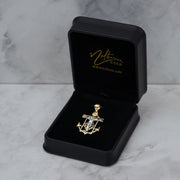 14k gold anchor pendant displayed inside an open black velvet gift box on marble.