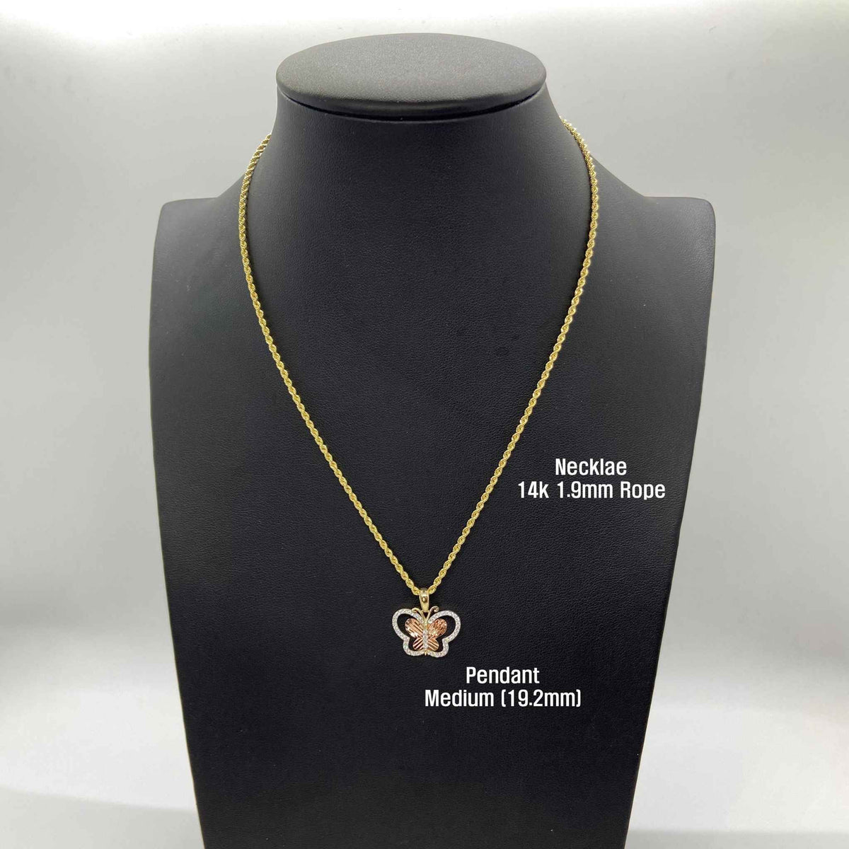 Front view of Medium 14k gold butterfly pendant necklace on black display bust.