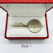 14k Gold ring with infinity design and silver coin next to it for reference in a red jewelry box