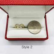 14k Gold infinity ring in a red box with a silver dollar coin for scale.