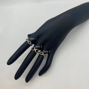 Black mannequin hand wearing three different styles of 14k gold infinity rings on a white background