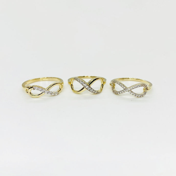 Three 14k gold infinity rings with Cubic Zirconia accents on a light gray background