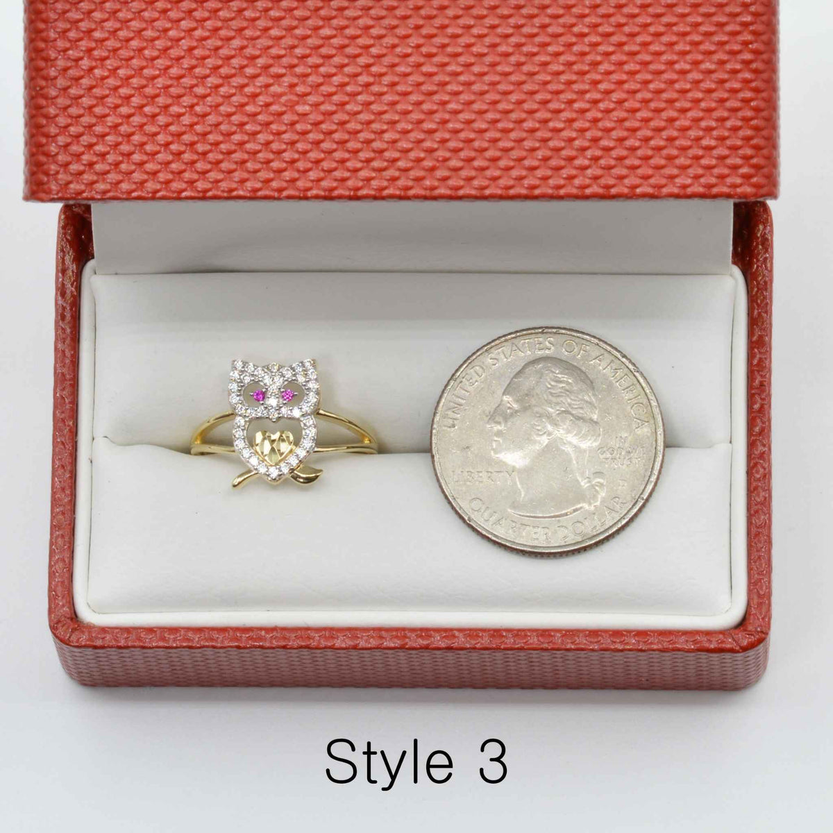 14k Gold ring with owl design and Cubic Zirconia in a jewelry box with a quarter for scale.