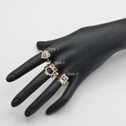Three 14k gold owl rings with different designs on a black mannequin hand against a white background.