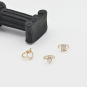 14k Gold owl rings with Cubic Zirconiaon a white surface with a black handle in the background