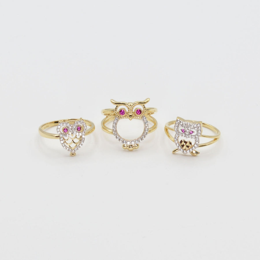 Three 14k gold owl shaped rings with different styles on a white background