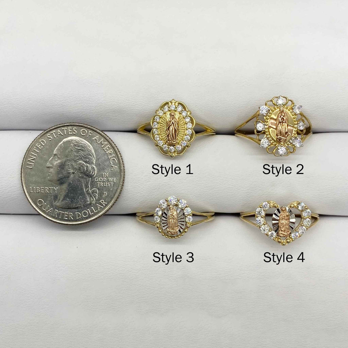 Four 14k gold Virgin Mary rings with different design next to a quarter.
