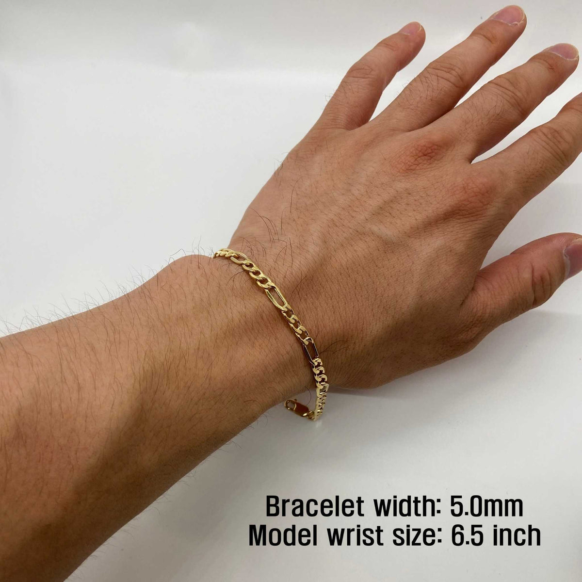 14k gold 5.0mm Figaro chain bracelet worn on a 6.5-inch wrist.