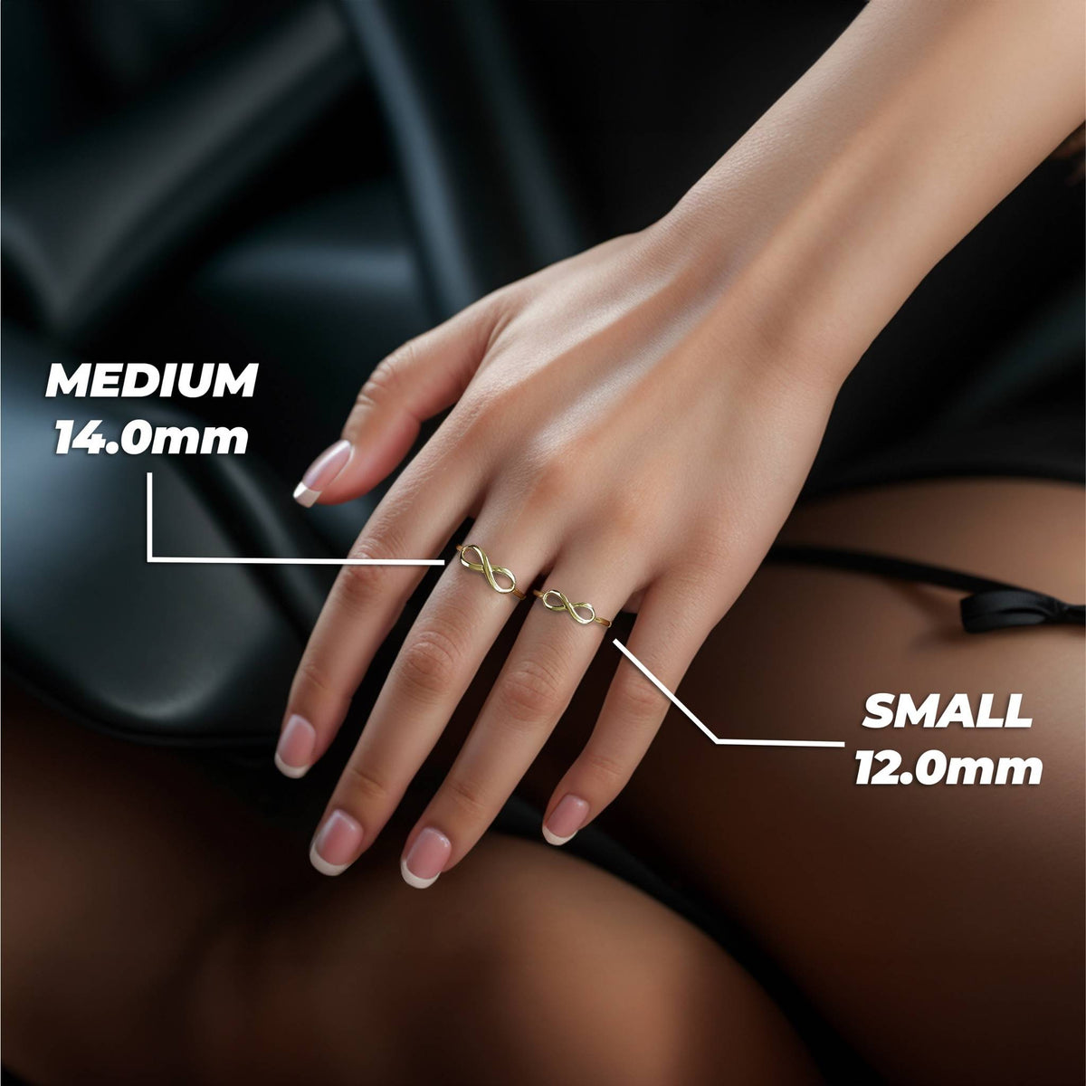 A woman’s hand wearing small and medium 14k gold classic infinity band rings.