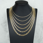 Five 14k yellow gold Mariner link chains displayed on a black neck bust model.