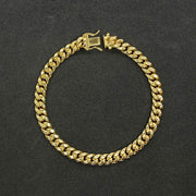 14k yellow gold Miami Cuban link bracelet arranged in a circle on dark surface.