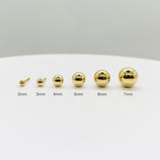 Size guide for 14k yellow gold ball stud earrings, showing 2mm to 7mm options for scale.