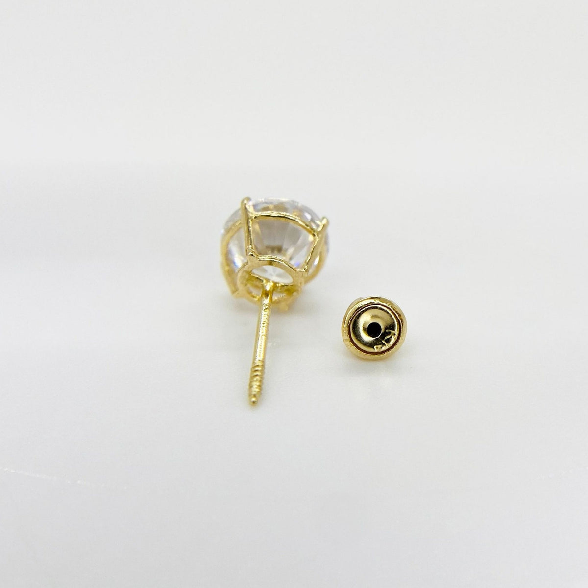 Back view of 14k yellow gold round solitaire CZ stud earrings, showing the post and secure screw back.