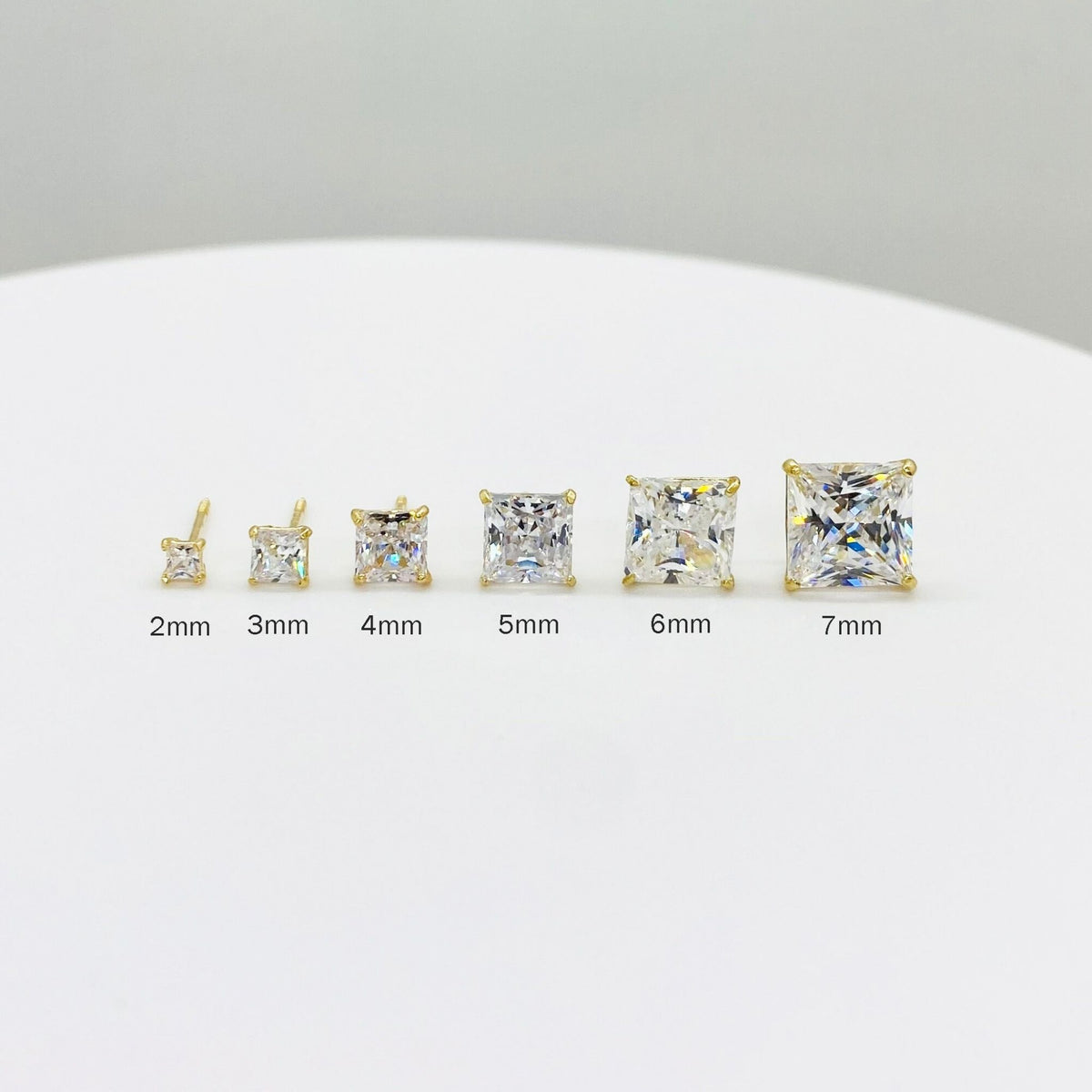Size comparison of 14k gold square CZ stud earrings ranging from 2mm to 7mm.