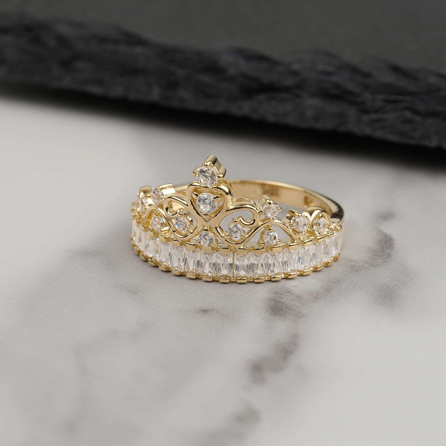 14k gold Eler crown ring set with cubic zirconia stones on marble background.