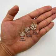 Hand holding Small, Medium, and Large gold crucifix heart pendants for size comparison.