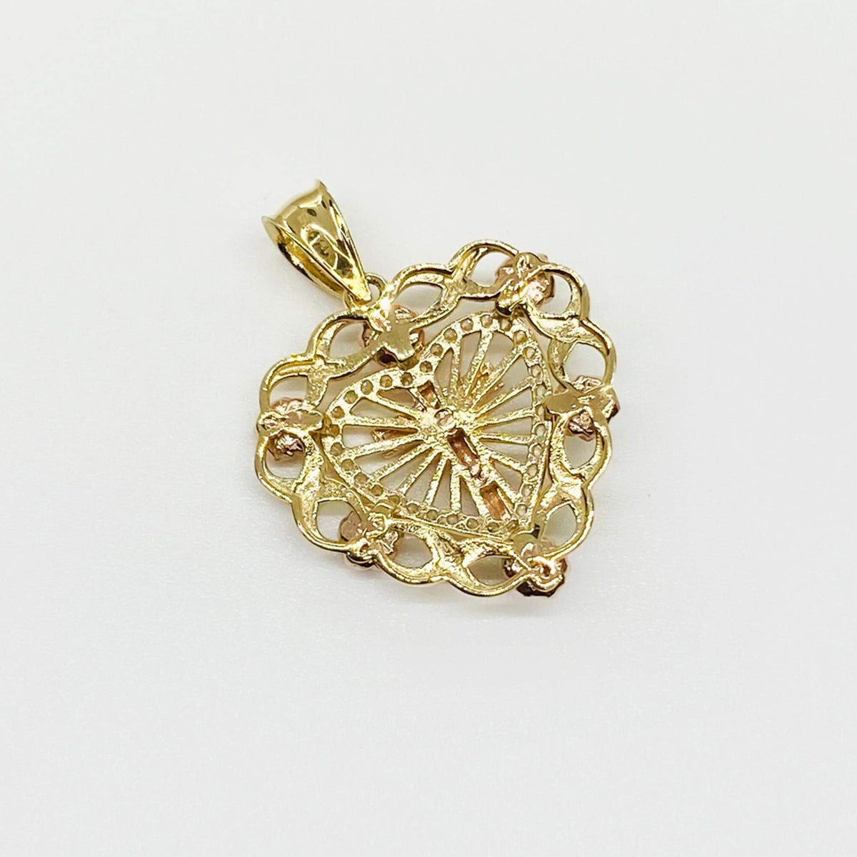 Back view of a 14k gold crucifix heart pendant displaying metalwork and stamp details.