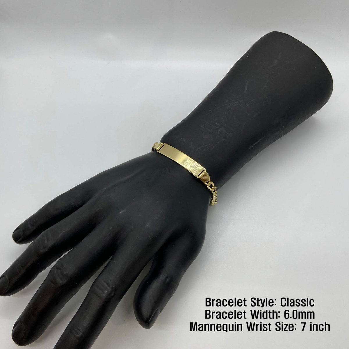 Black mannequin wrist display wearing a 6.0mm 14k gold Classic style ID bracelet.