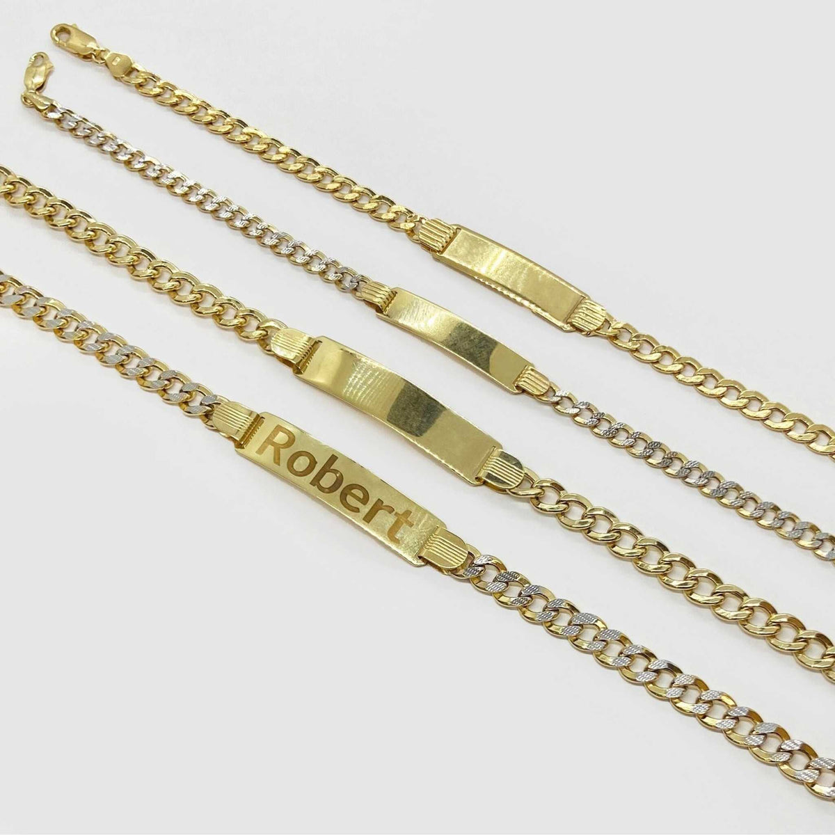 Close-up of a 14k gold personalized ID bracelet showing a lobster clasp and hallmark.