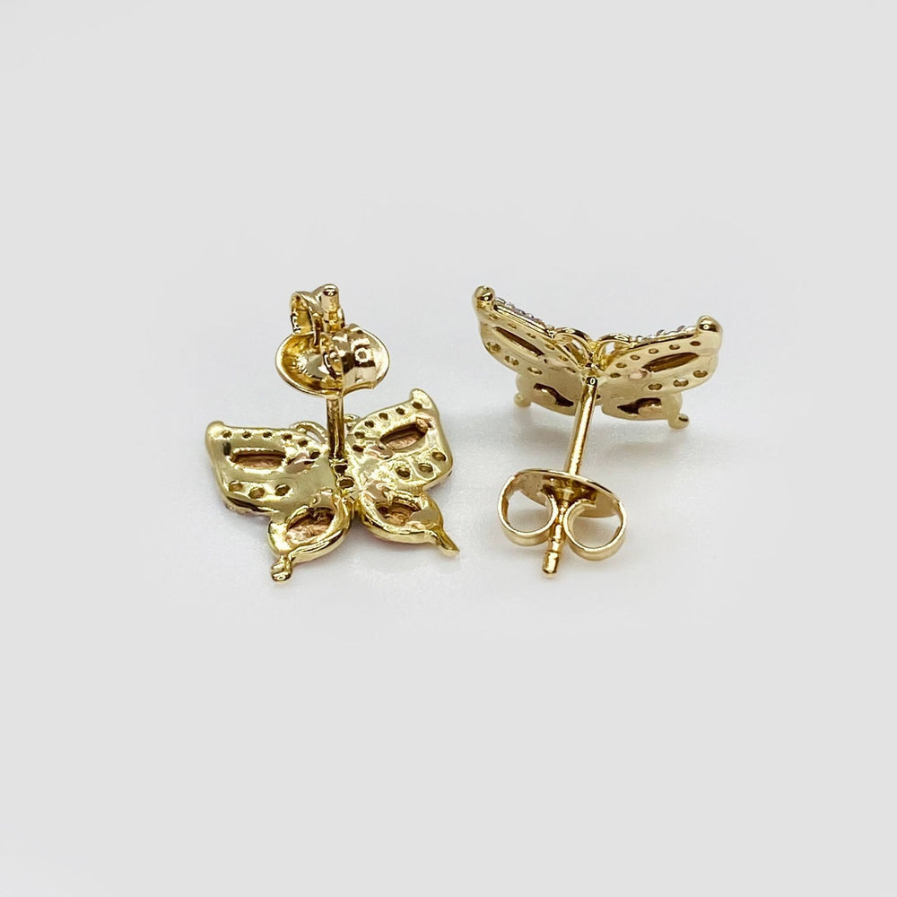 Rear view of gold butterfly stud earrings with push-back closures on white background.