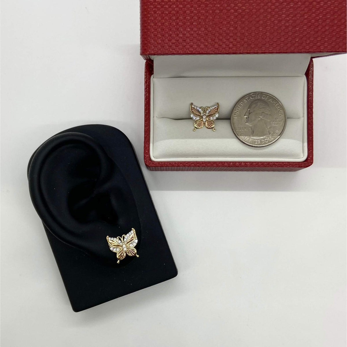Gold butterfly earrings displayed next to a quarter and a red jewelry box.