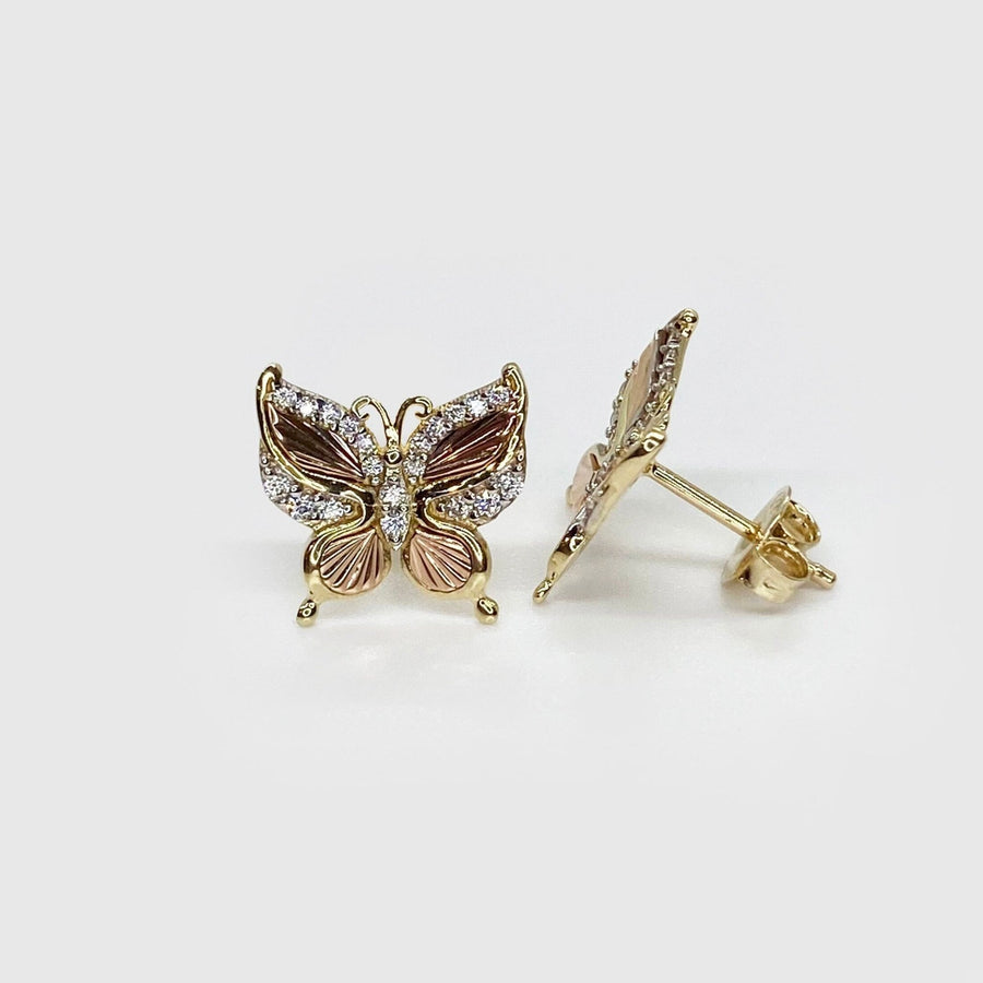 Front and profile view of gold and rose gold butterfly stud earrings with stones.