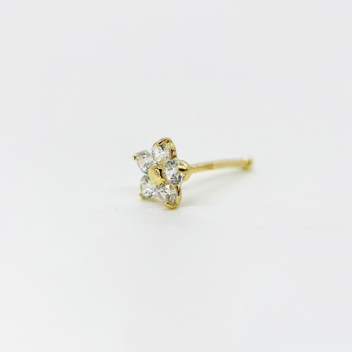 14k gold flower nose stud with clear cubic zirconia petals on plain white background.