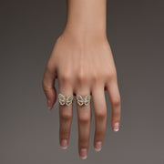 Model wearing two gold butterfly rings featuring intricately paved crystal wings.