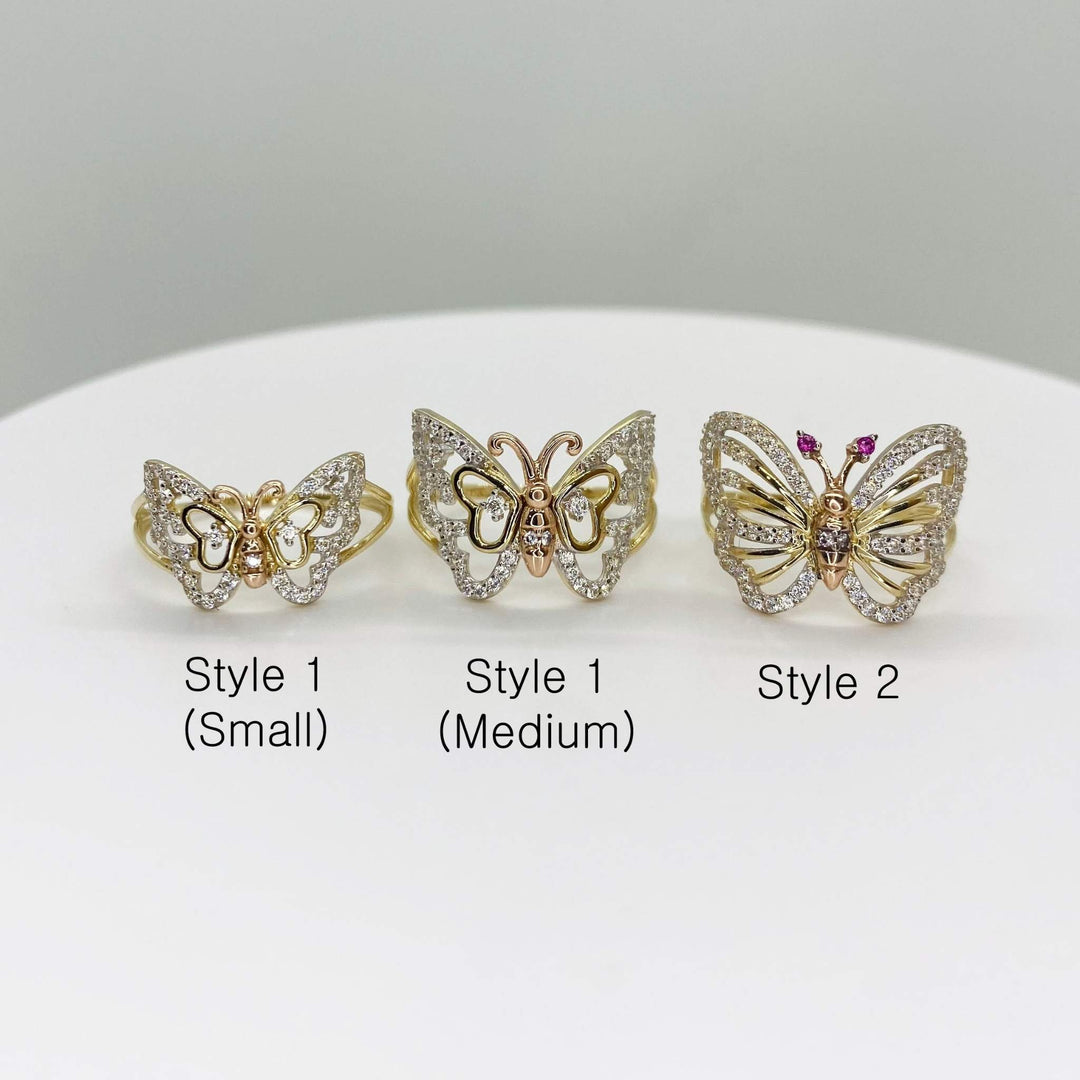 Three 14k gold butterfly shaped rings labeled with size and style on a white surface.