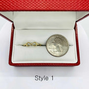 14k Gold ring with infinity symbol next to a quarter coin in a red jewelry box.