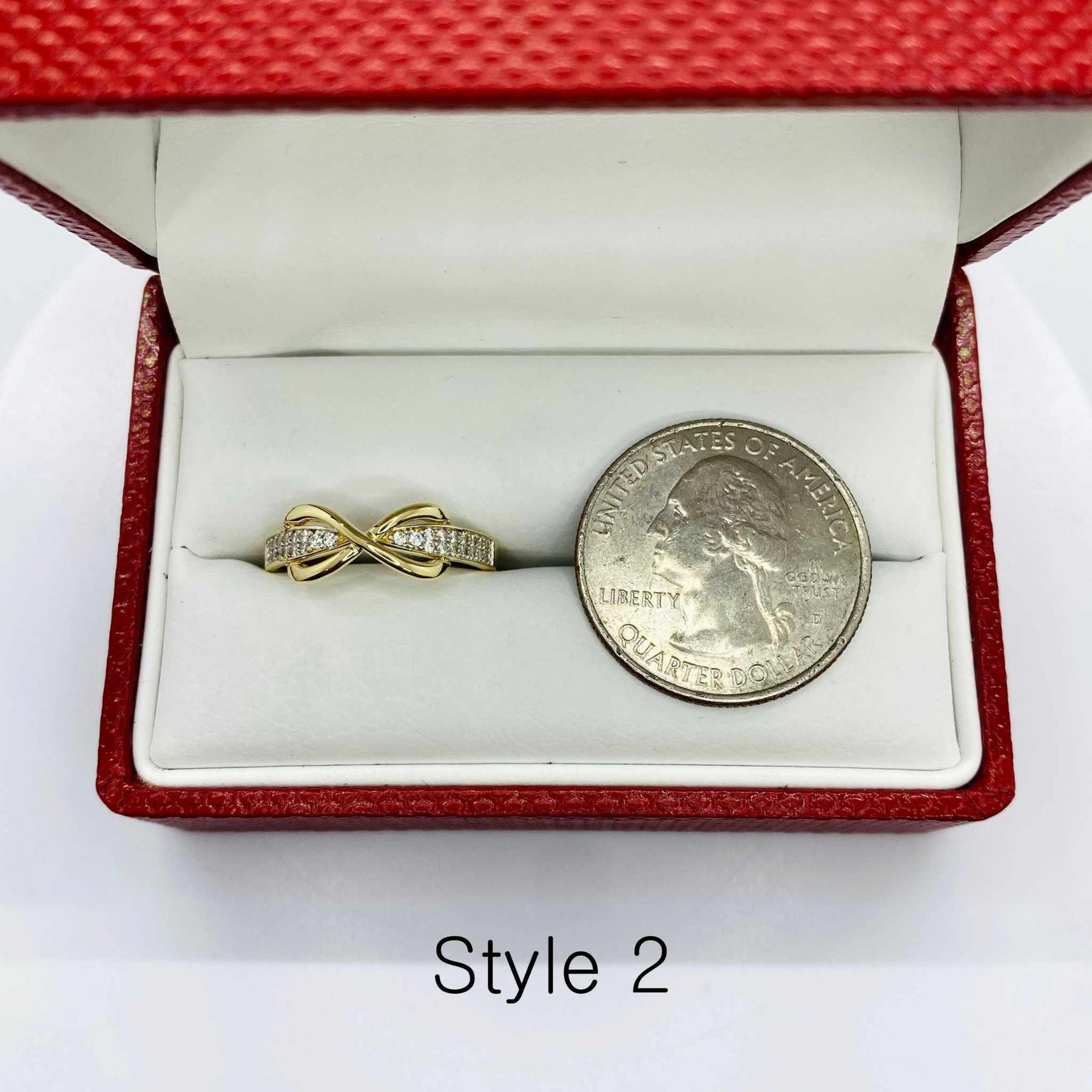 14k Gold  Infinity shaped ring in a red jewelry box with a quarter for scale 