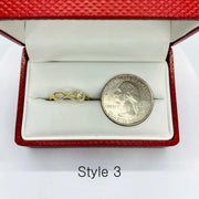 14k Gold ring with a Infinity design next to a coin in a red jewelry box labeled Style 3