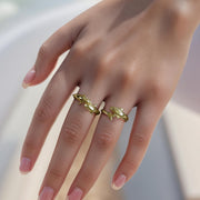 Hand model wearing 14k gold Kari dolphin ring styled on a neutral background.