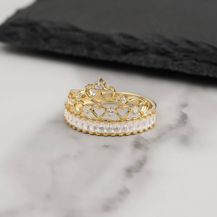 14k gold crown ring set with cubic zirconia stones on marble background.
