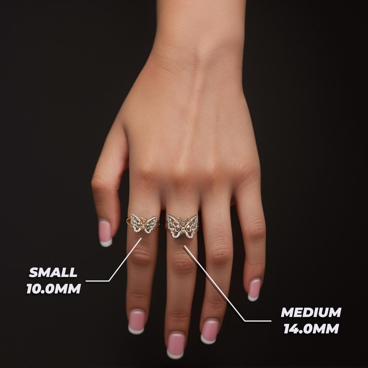 Model's hand wearing small and medium gold Mary butterfly rings with millimeter size labels.