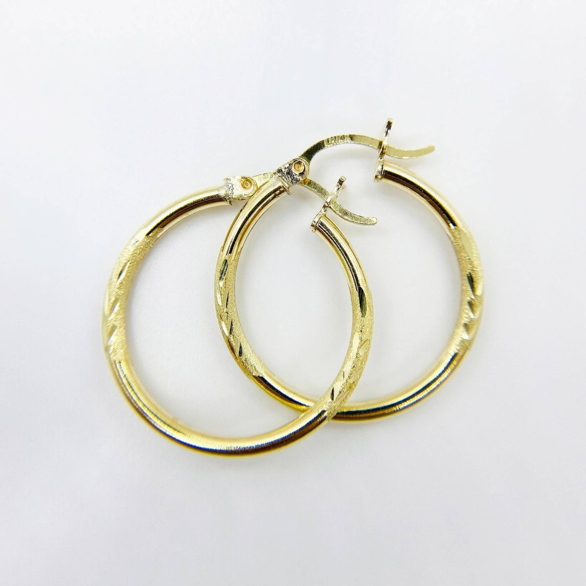 air of 14k yellow gold 2mm tube hoop earrings featuring elegant matte diamond cutting.
