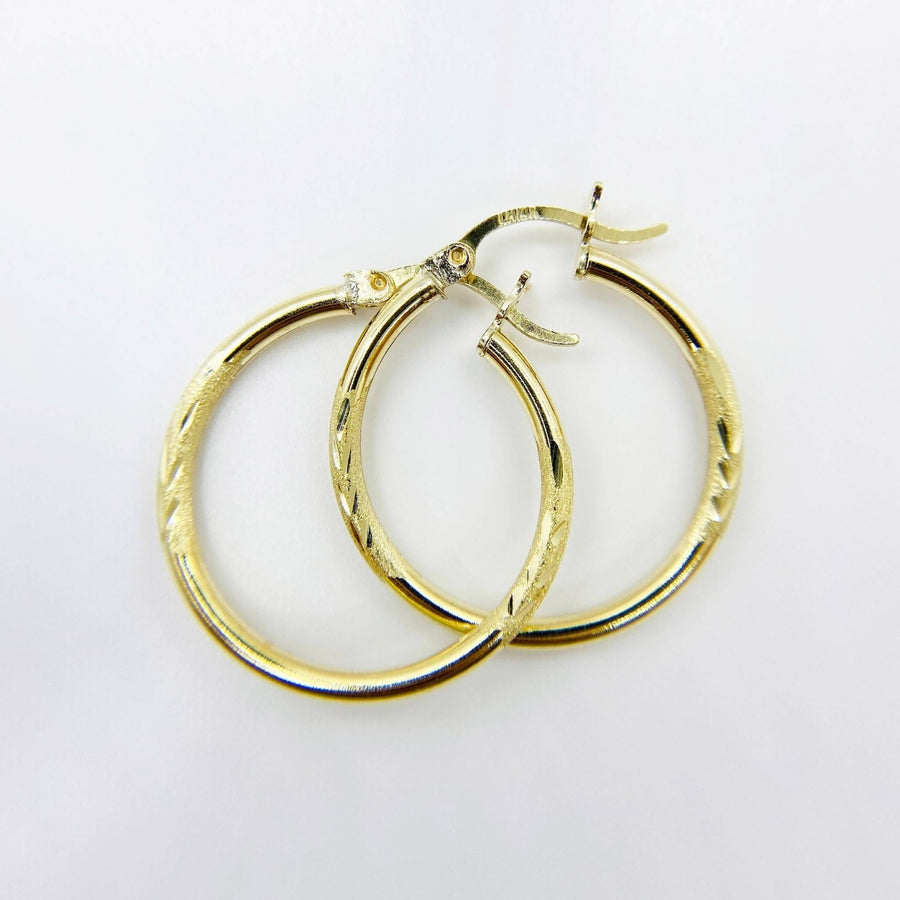air of 14k yellow gold 2mm tube hoop earrings featuring elegant matte diamond cutting.