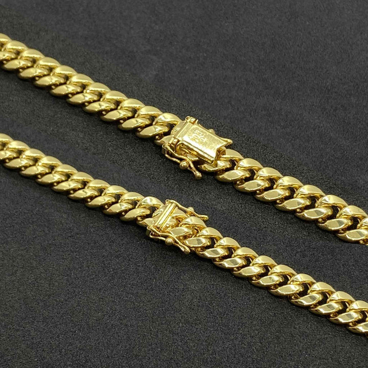 Two 14k gold hollow Miami Cuban chain bracelets with box lock clasps on black background.