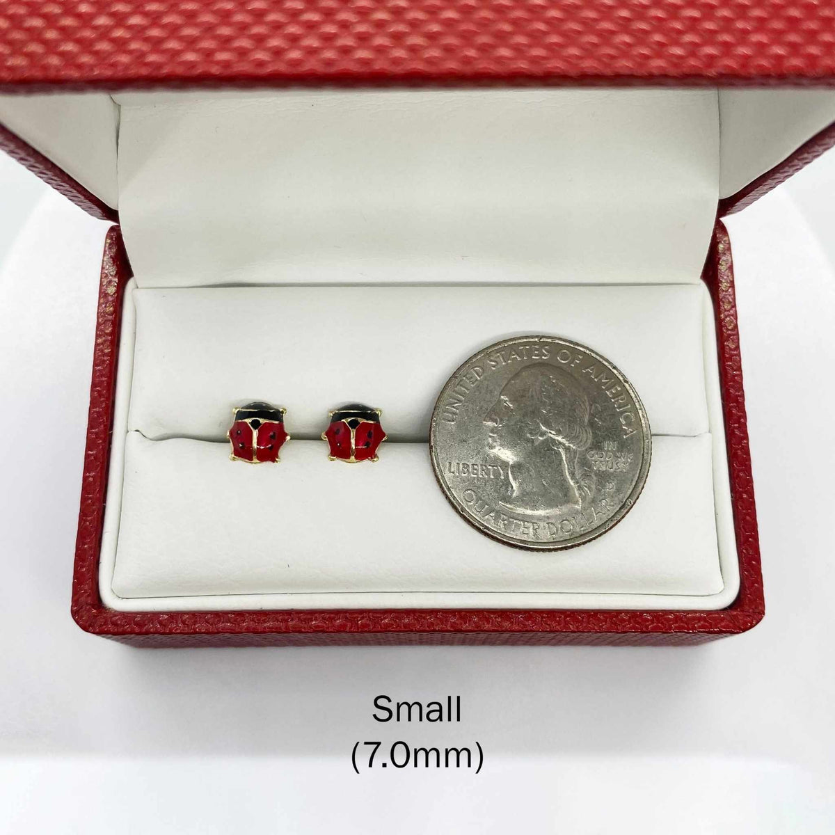 14k gold Small 7.0mm ladybug stud earrings shown next to a US quarter for size reference.