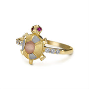 Side profile view of a 14k tri-color gold turtle ring with cubic zirconia.