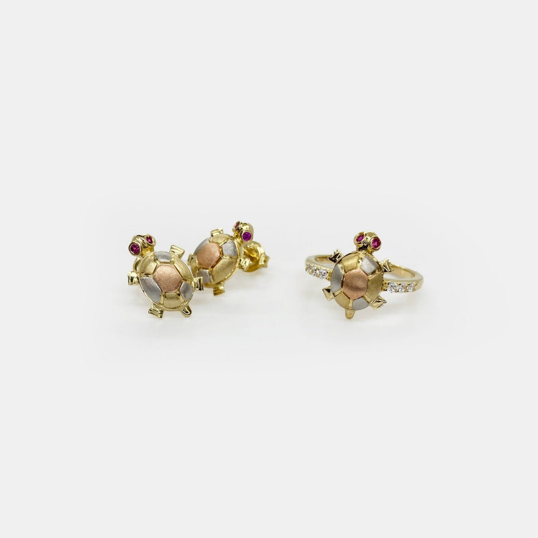 three 14k Gold turtle shaped rings with Cubic Zirconia on a white backgroundstones