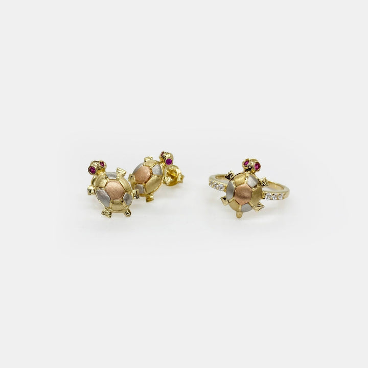 three 14k Gold turtle shaped rings with Cubic Zirconia on a white backgroundstones