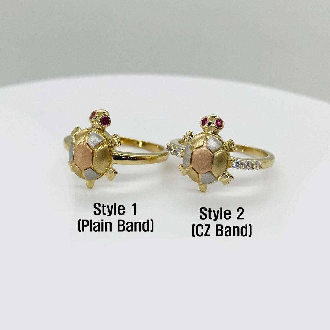 Two turtle shaped 14k gold rings with different band designs on a white background