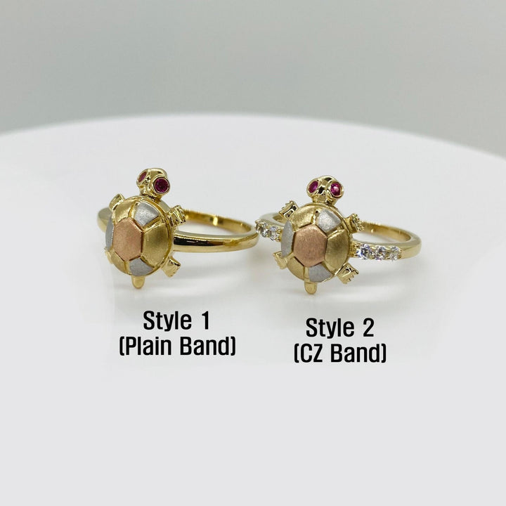 Two turtle shaped 14k gold rings with different band designs on a white background
