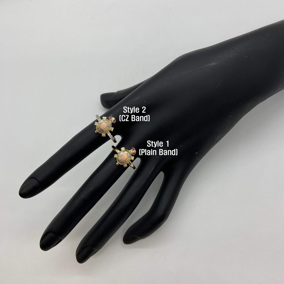 Two 14k gold rings with mini turtle design on a black mannequin hand with labels indicating styles.