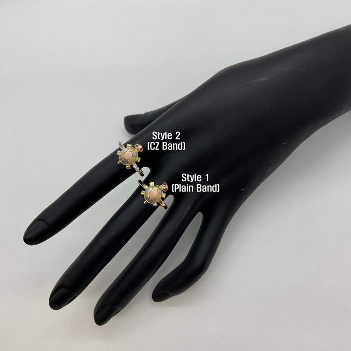 Two 14k gold rings with mini turtle design on a black mannequin hand with labels indicating styles.